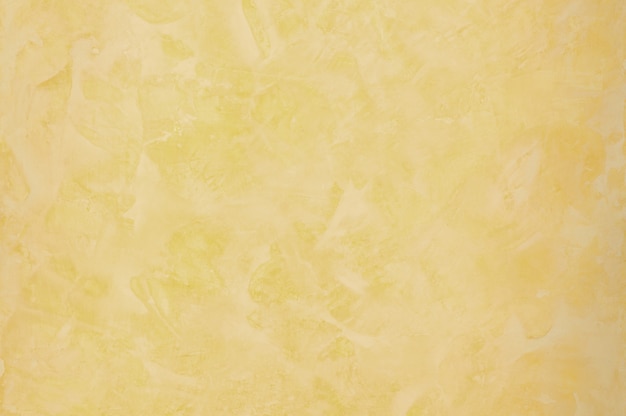 Background of the plastered texture with marble effect gold color. artistic background handmade