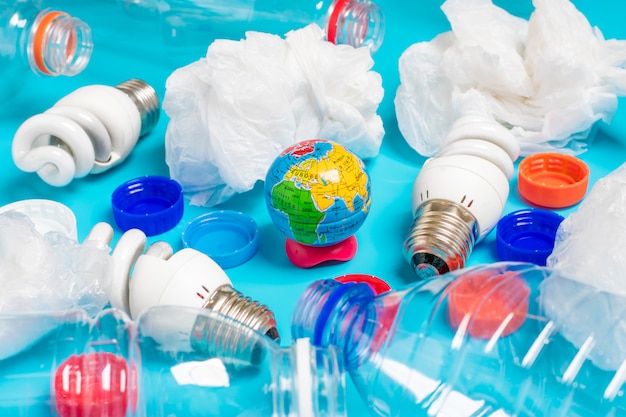 Background of plastic bottles of transparent, plastic bags,\
fluorescent, globe. flat lay