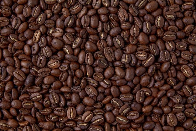 ランダムに散らばった焙煎コーヒー豆の背景。プレゼンテーションのレイアウト。