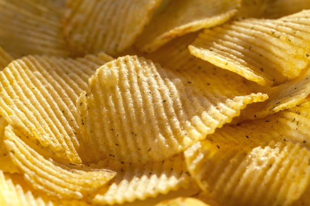 Background of ridged potato chips with spices. 