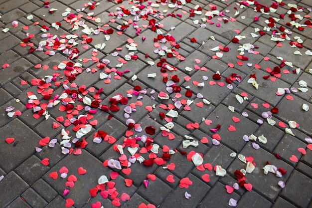 Background of rose petals on the pavement, heart shape. Wedding theme.