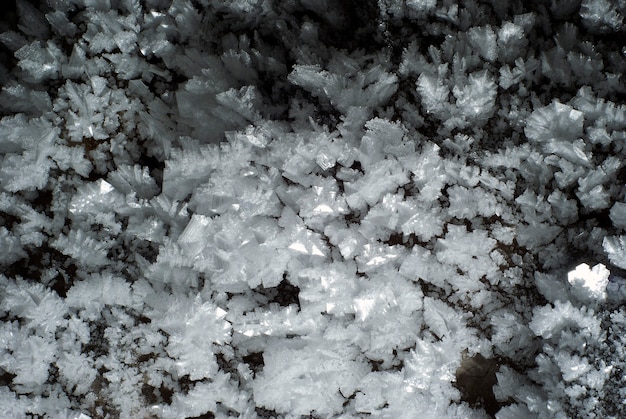 Foto sullo sfondo una sezione della parete della grotta ricoperta da grandi cristalli di ghiaccio