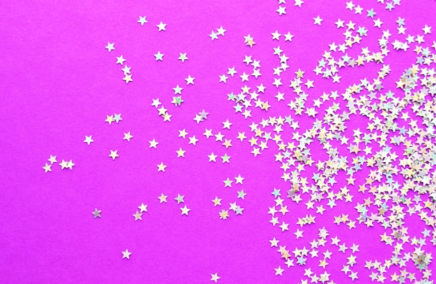 Background of shiny little stars on a bright pink background. Christmas concept. Glitter texture.