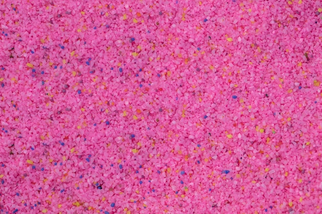 Background of small pebbles of pink color Pink sand texture