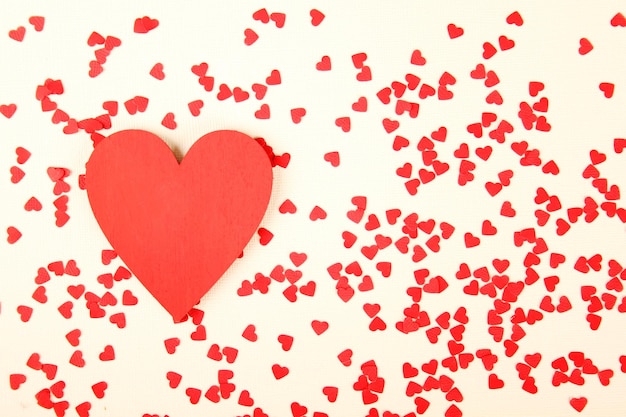 background of small red hearts scattered on the yellow background