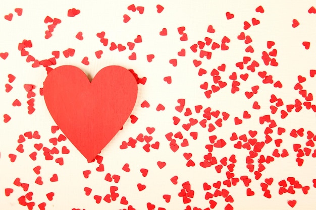 Background of small red hearts scattered on the yellow background