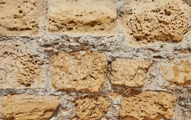 Background of the stone wall of the castle made of stones of different shapes and sizes and textures.