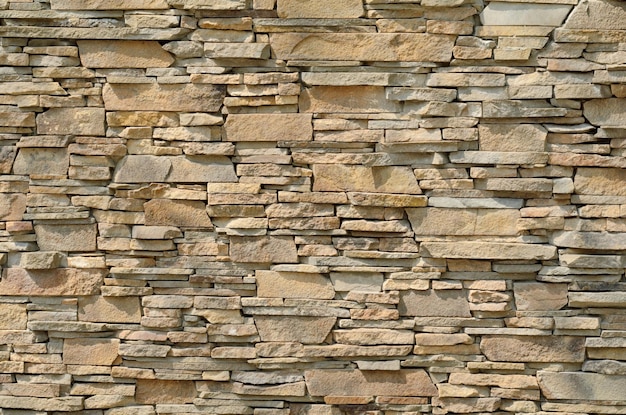 Background of a stone wall cladding texture brown stone bricks