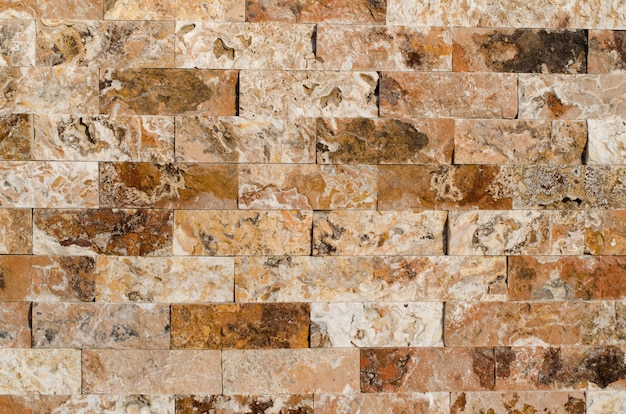 Background of a stone wall cladding texture, brown stone bricks 