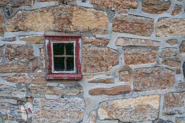 Foto sfondo di un muro di pietra di un forte con una piccola finestra