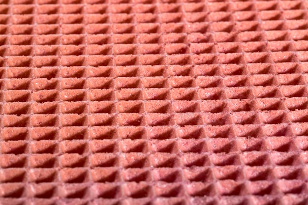 Background and surface texture of a confectionery waffle in pink color