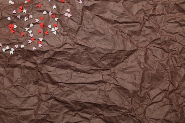 Background texture brown paper crumpled with scattered heart red pink and white for valentine's day. High quality photo