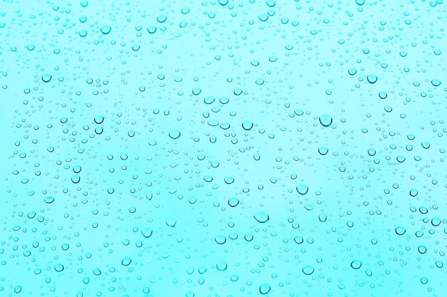 фон и текстура капли воды на синем стекле.