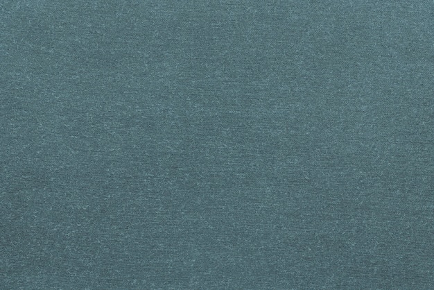 Background and texture of knitted or woolen fabric of monotonous dark turquoise color