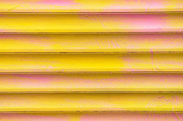 Background and texture of metal gates in yellow and pink colors.