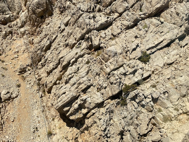 Background and texture of mountain layers and cracks in sedimentary rock on cliff face