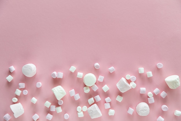 Photo background or texture of pink and white mini marshmallows on pink background with free space for text