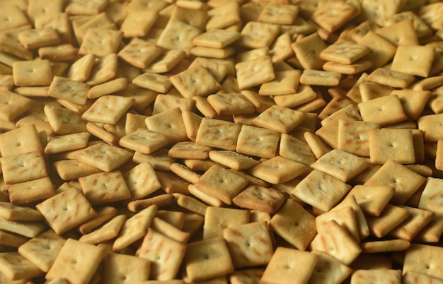 Background texture of small edible squares baked from dough and sprinkled with salt a lot of salt