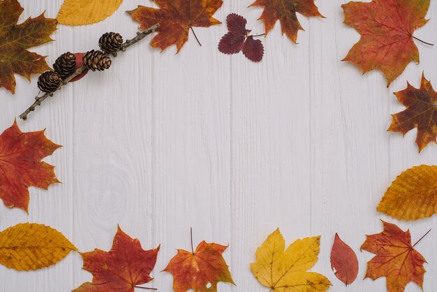 Background texture with old wooden table and yellow autumnal leaves. Top view