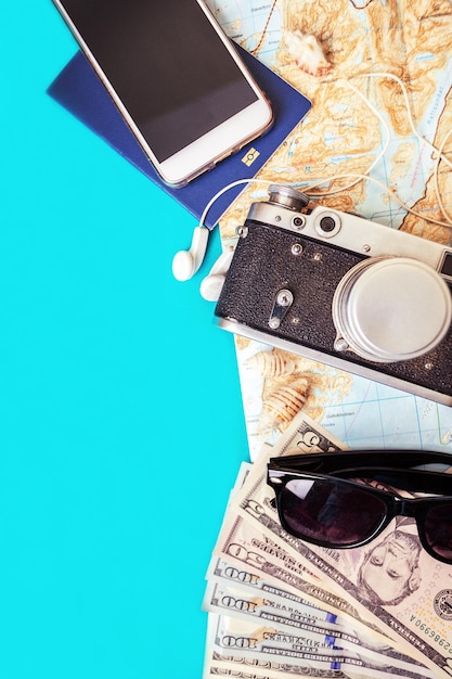 Background for a trip - sneakers, map, dollars, glasses, camera, headphones