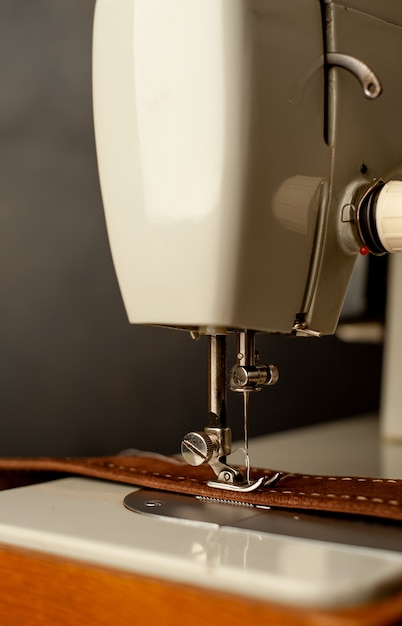 Background type of sewing machine, leather belt sewing process. Leather workshop.