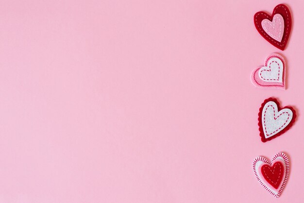 The background of Valentine's day. Border of beautiful different hearts on a pink background