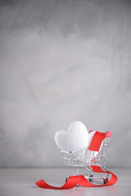 Background for Valentine's Day greeting card.Valentines day concept.Hearts in a shopping cart.