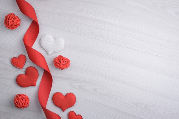 Background for Valentine's Day greeting card.Valentines day concept.Red gift ribbons, gifts, hearts on a wooden background. Top view.