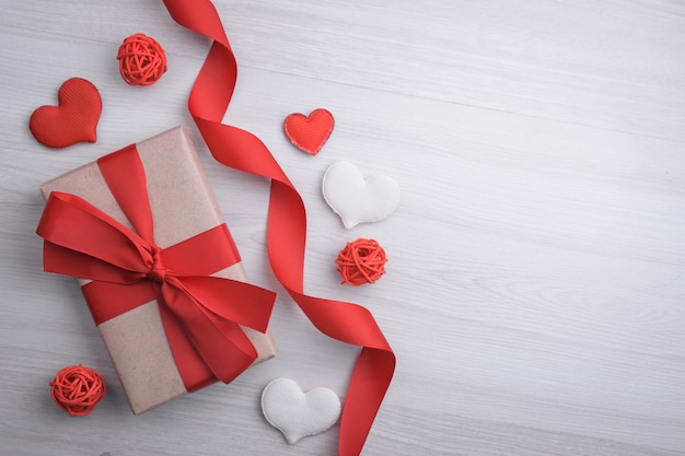 Background for Valentine's Day greeting card.Valentines day concept.Red gift ribbons, gifts, hearts on a wooden background