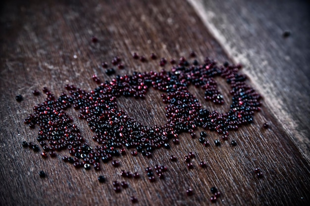 Background for Valentines day Heart shape in a  heap of beads  I love you Wooden pattern