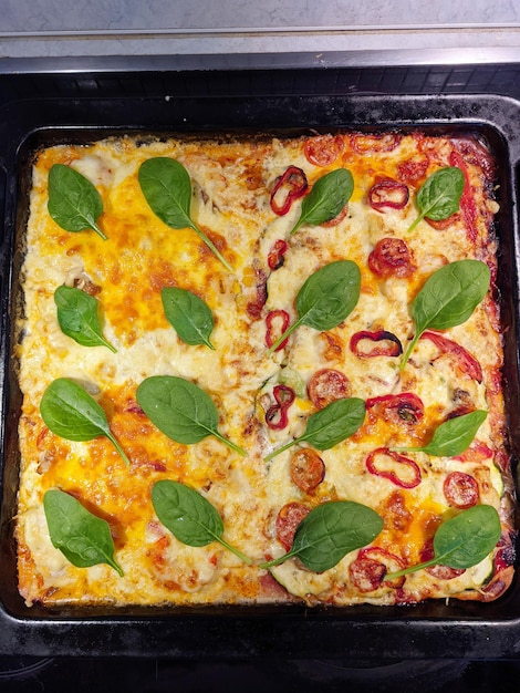 Background of vegetarian pizza with tomatoes, cheese, herbs, red pepper close up. Top view, flat lay