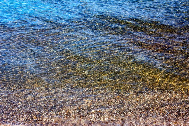 Background of the water of Lake Traunsee in the coastal area Colorful texture of stones under water