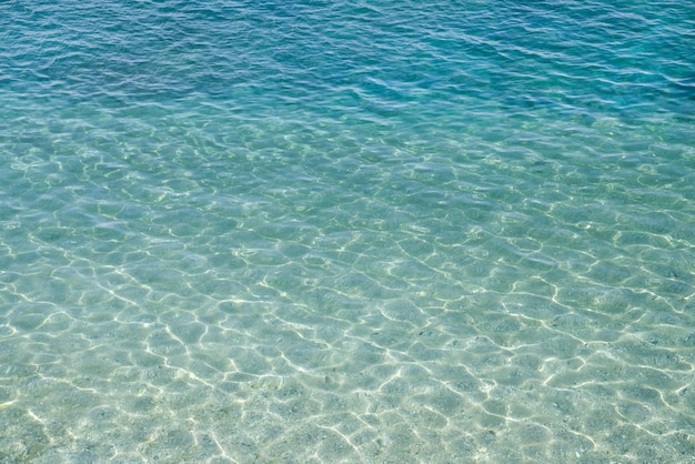 Foto lo sfondo della superficie dell'acqua i raggi del sole brillano sulla superficie dell'acqua vista dall'alto