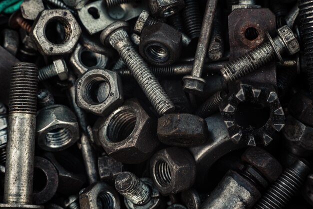 Background with bolts screws and other repair parts in closeup metal parts for various repairs macro