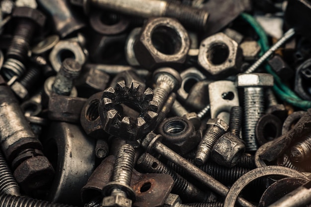 Background with bolts screws and other repair parts in closeup metal parts for various repairs macro