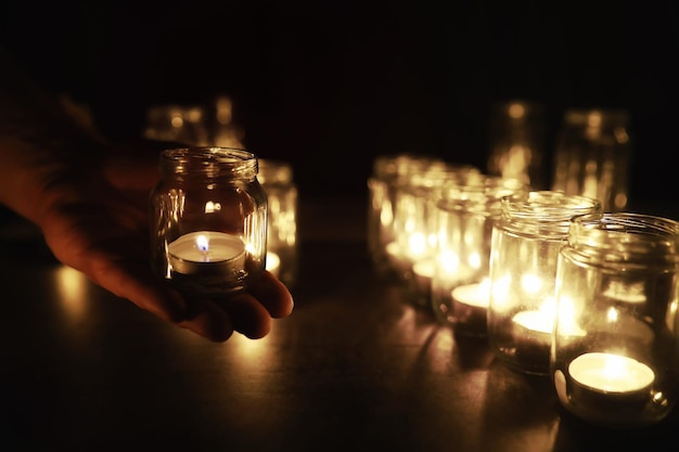 Background with candles in glass vessels candles burn in a dark\
place rest in peace