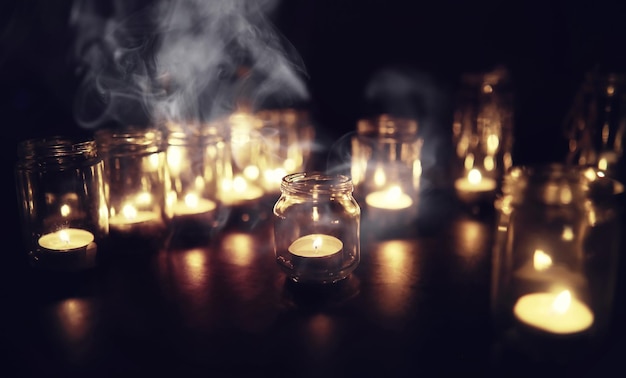 Background with candles in glass vessels candles burn in a dark\
place rest in peace