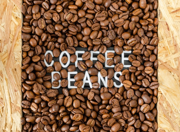 Background with coffee beans with white inscription in the middle.