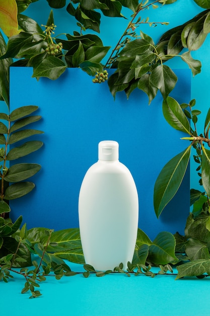 Background with green leaves and plants and bottle of cosmetic. Natural scin care concept