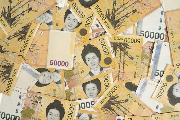 Photo background with multiple korean 50,000 won banknotes.