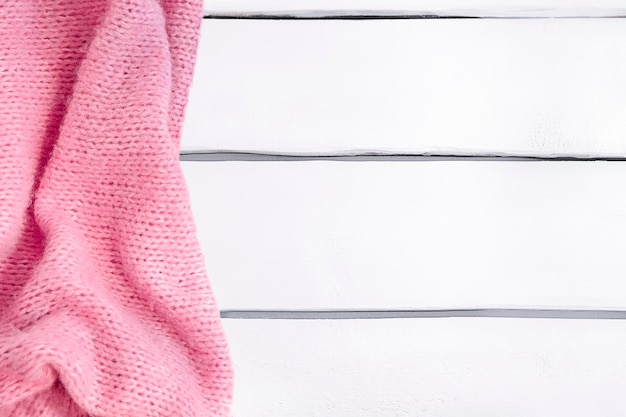 Photo background with pink knitted blanket on white wooden table mockup