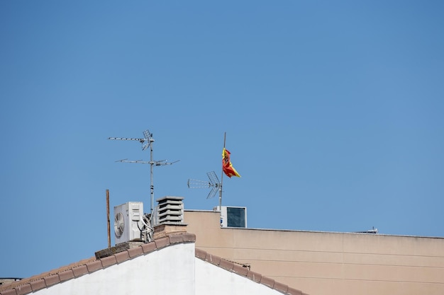 구름 없는 파란 하늘을 배경으로 스페인의 타일로 된 집 지붕