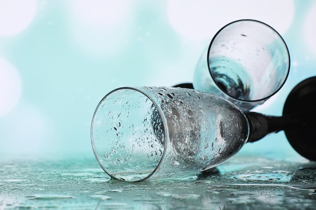 Background with tall glasses for sparkling wines. Champagne and spray in glass glasses. Celebratory drink with reflection.