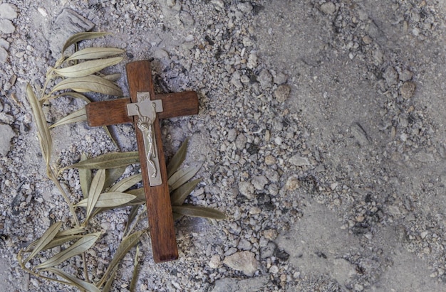 Sfondo con trama di ceneri grigie, ramo d'ulivo e croce. concetto di mercoledì delle ceneri