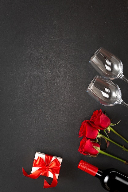 Foto sfondo festa della donna o san valentino. vino, rose rosse, confezione regalo.