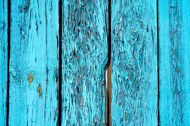 Background of wooden boards painted blue with scratches and chips