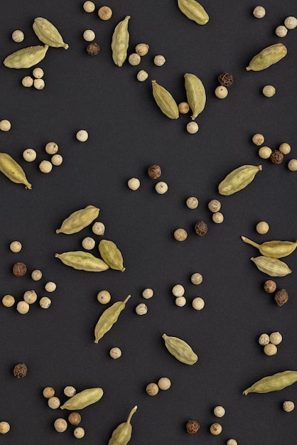 Backgrounds and textures spices Cardamom and peppercorns on a black background