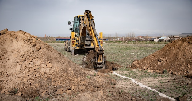 Backhoe bucket digging the soil at agriculture