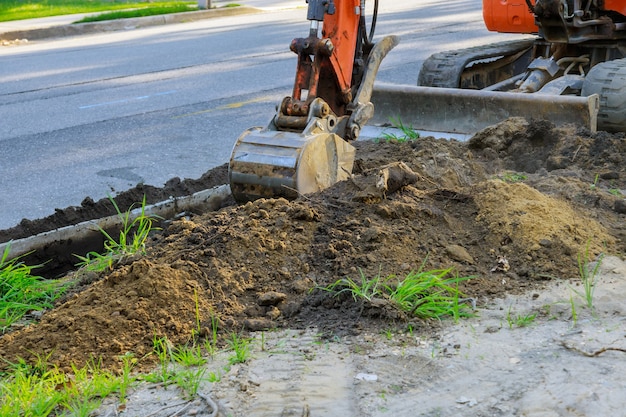 Backhoe on road work digger working at construction in excavation pit