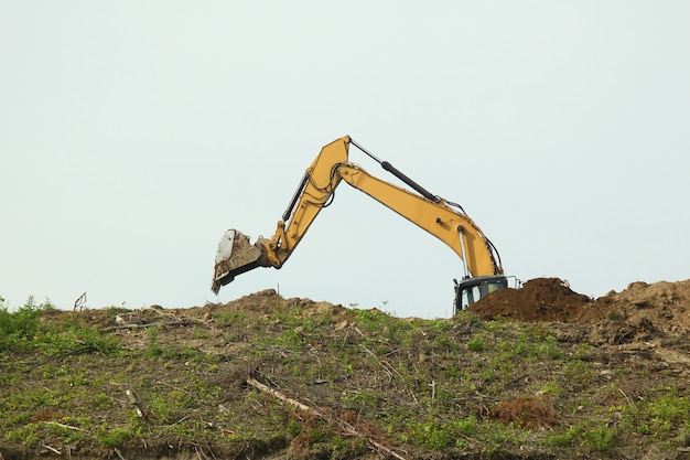 The backhoe was digging soil on top mountain